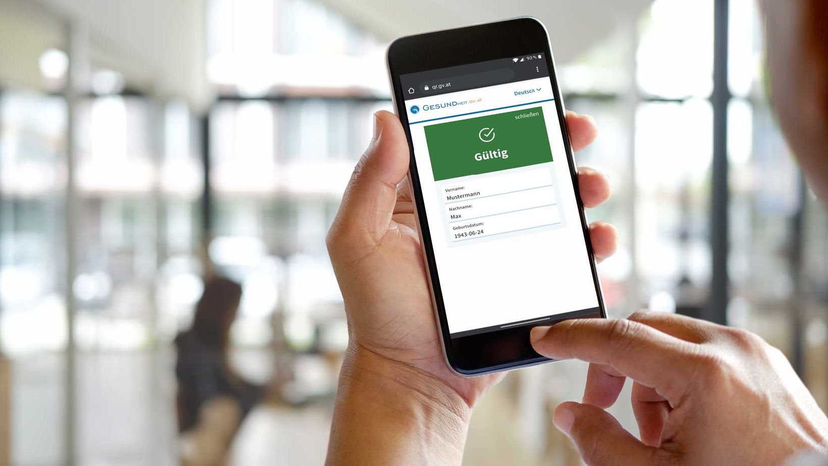 Grüner Pass, @BRZ - iStock.com/BongkarnThanyakij Handy mit grünem Pass am Bildschirm